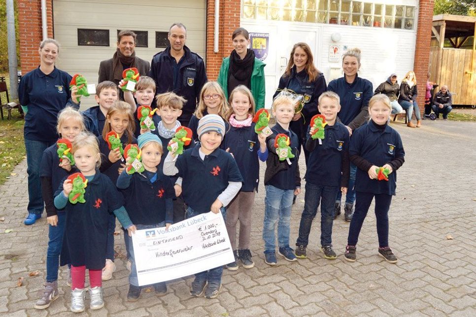 Einen Spendenscheck über 1.000 Euro überreichte Sabine Nosthoff (grüne Jacke) an die Kinderfeuerwehrabteilung. Für jedes Kind wurde davon schon einmal ein putziges Maskottchen angeschafft.