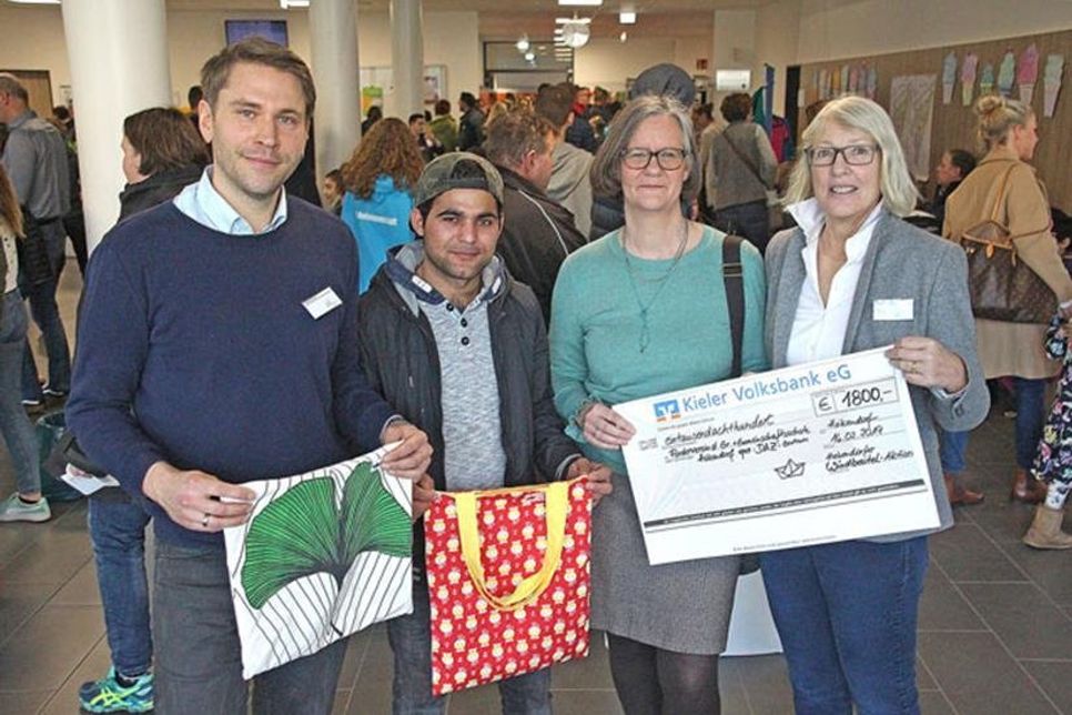 Scheckübergabe der Windbeutel-Aktion: Brigitte Peschties (Schulleiterin) Ina Spielhagen-Göser (Bücherinsel) Siddiqullah Siddiqi (Schneider aus Afghanistan) und Fabian Lamp (Förderverein GGS) von rechts.