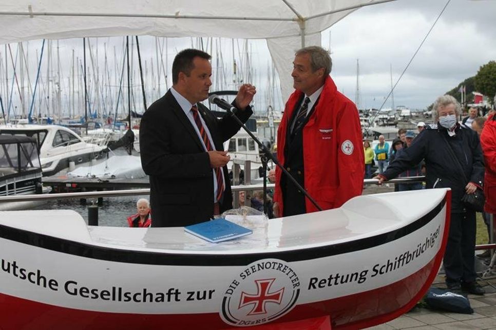 Bürgermeister Mark Burmeister überreichte eine Grömitz-Sonne und ein Grömitz-Buch an Ingo Kramer (re.).