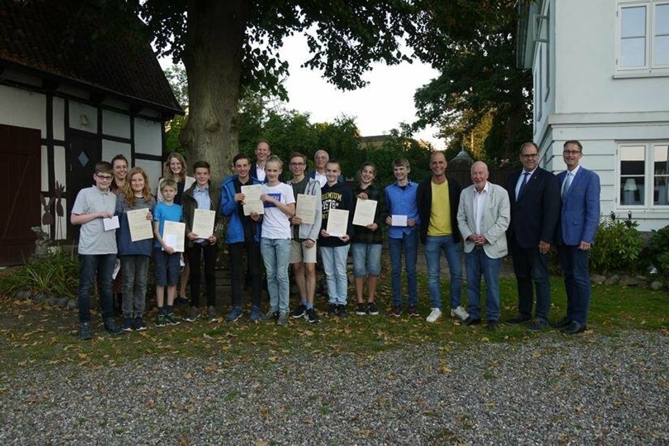 Das Foto zeigt die stolzen Preisträger mit ihren Urkunden, der Schulleitung, Karsten Kilian und Ralf Hübner, den betreuenden Lehrerinnen Nadja Schömig und Judith Schidlo, den Vertretern der Stadt Neustadt, Bürgermeister Mirko Spiekermann, Bürgervorsteher Sönke Sela) und vom Rotary Club Neustadt-Ostsee Präsident Axel Sommerlatt sowie MINT-Projektleiter Georg Heerten im Bereich der Hofanlage Marienhof.
