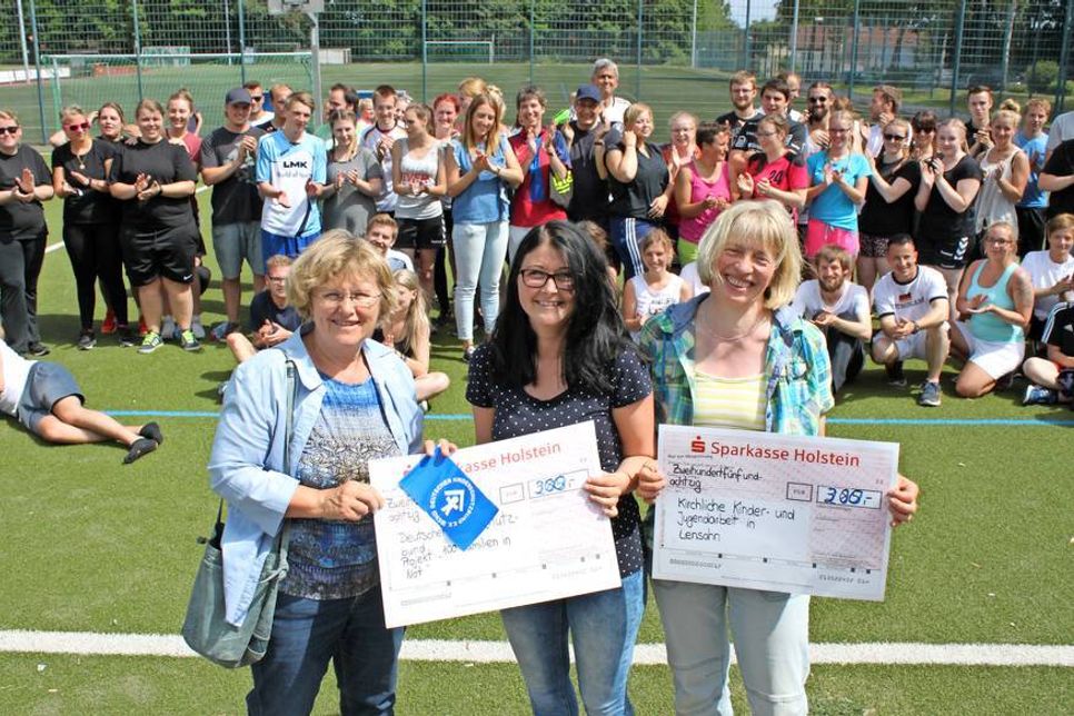 Spendenübergabe vor den applaudierenden Schülern: Mechtild Piechulla, Öffentlichkeitsbeauftragte der Veranstaltung Rebecca Hattenbach und Schülerin Anette Beth (v. lks.).