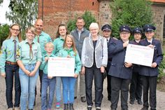 Spendenübergabe vor der St. Nicolaikirche mit Vertretern der Pfadfinder, der Jugendfeuerwehr, Karin Siems und Pastor Holger Lorenzen.