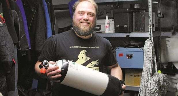 Martin Roos zeigt eine Pressluftflasche, mit der er rund 60 Minuten unter Wasser tauchen kann
