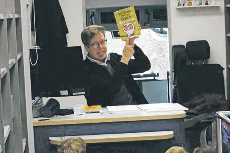 „Unterm Bett liegt ein Skelett“: Im Rahmen der lustigen Lesung im Bücherbus der Fahrbücherei nutzte Autor Arne Rautenberg im Dialog mit den Trenter Schulkindern eine Reihe von Bildern.