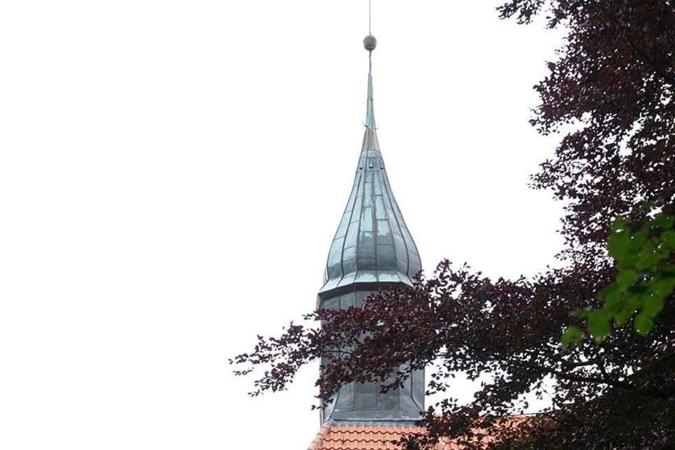In Süsel grüßen Kühe von der Weide, historische Bauernhäuser stehen unter alten Bäumen, und das Kirchengeläut der spätromanischen St.-Laurentius-Kirche begleitet das Dorfleben.