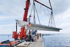 Das erste 45 Tonnen schwere Stahlbetonfertigteil der nördlichen Balkone schwebt über der neuen Scharbeutzer Seebrücke.