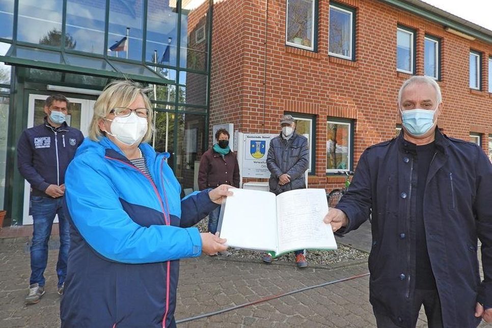 Annegret Vogelsang (lks.) übergab die gesammelten Unterschriften an Bürgermeister Adrianus Boonekamp (re.). Im Hintergrund Stephan Alm, Dorfvorsteherin Petra Landschoff und Eckhard Meier.