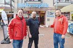 Große Freude bei Christian Buhk (links), stv. Vorsitzender der DLRG Haffkrug-Scharbeutz, und dem stv. Schatzmeister Dennis Themer, die die Spende in Höhe von 600 Euro aus den Händen von „Jimmy“ Imholt („Küstenoptik“, Mitte) entgegennehmen.