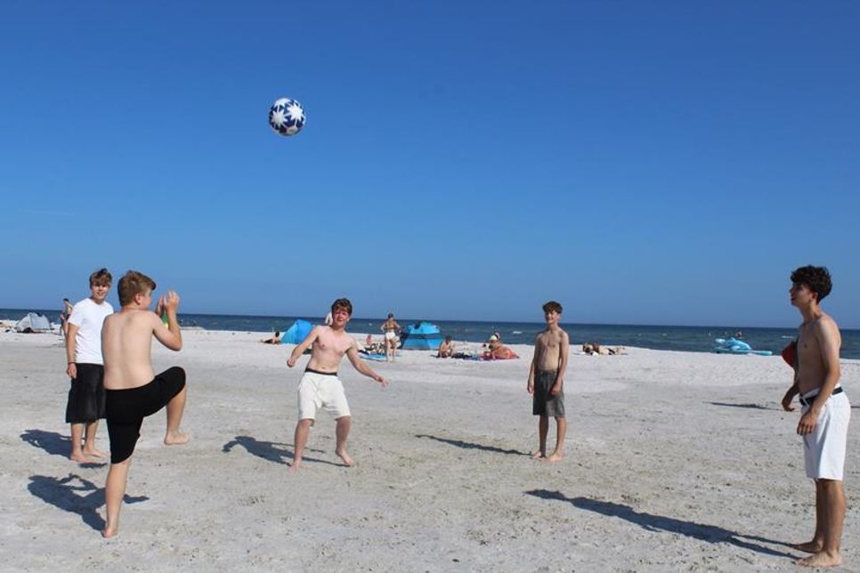 Ballspiele am Strand bei strahlendem Sonnenschein.
