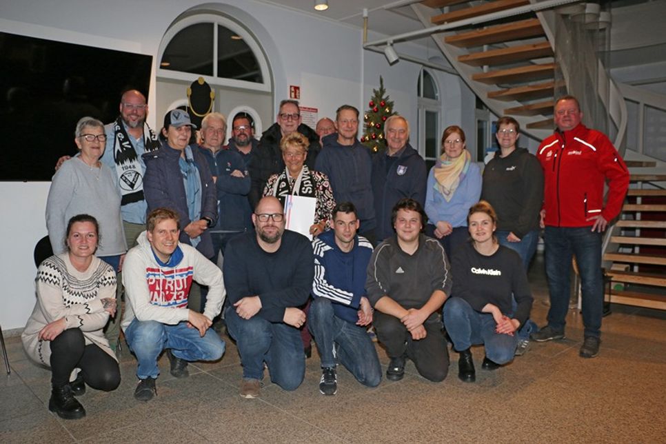 Mit der frischgebackenen „Moin! Vereinsheldin des Monats Dezember“ Christine Reimers (Mitte, mit Urkunde), die gemeinsam mit ihrem aus gesundheitlichen Gründen abwesenden Ehemann Herbert geehrt wurde, freuen sich Sven Puls (Sparkasse Holstein, stehend gan
