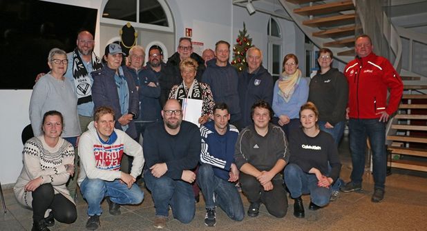 Mit der frischgebackenen „Moin! Vereinsheldin des Monats Dezember“ Christine Reimers (Mitte, mit Urkunde), die gemeinsam mit ihrem aus gesundheitlichen Gründen abwesenden Ehemann Herbert geehrt wurde, freuen sich Sven Puls (Sparkasse Holstein, stehend gan