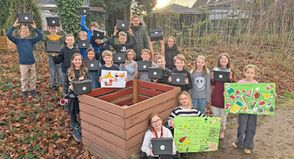 Mit alten Holzlatten – nachhaltig! – haben die Schüler der Klasse 4a einen Komposter gebaut. Die Sammelbehälter für den Biomüll hat das Abfallwirtschaftszentrum Rastorf, vertreten durch Jette Sick und André Schulz, spendiert.