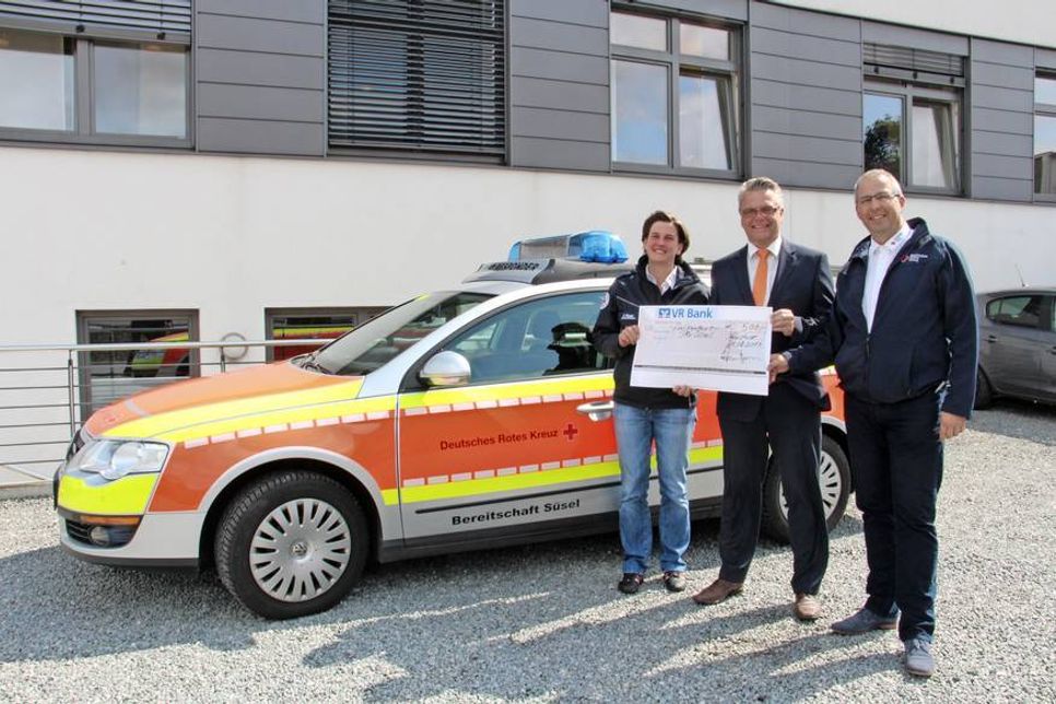 Nicole Riedel und Tino Jordt (re.) von der DRK-Bereitschaft Süsel mit Michael Poske von der VR Bank vor dem Einsatzfahrzeug der First Responder.