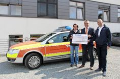 Nicole Riedel und Tino Jordt (re.) von der DRK-Bereitschaft Süsel mit Michael Poske von der VR Bank vor dem Einsatzfahrzeug der First Responder.