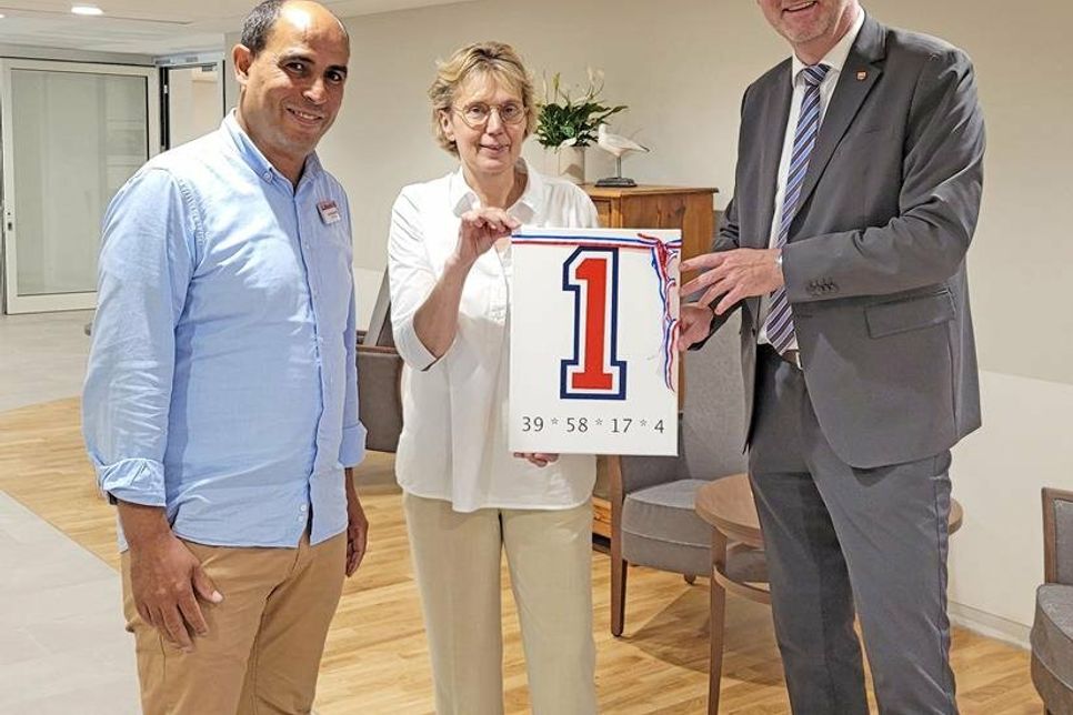 Pflegedienstleiter Abderrahim Ouled-Attou, Einrichtungsleiterin Susanne Sielaff-Untiedt und der Plöner Landrat Björn Demmin (v. l.) zeigen stolz die Nummer 1: Die Zahl für Erneuerung und Anfang.