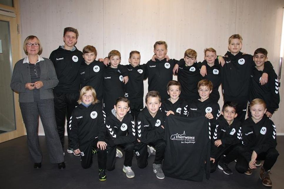 Mannschaft und Trainer bei der Übergabe mit Stadtwerke-Leiterin Vera Litzka.