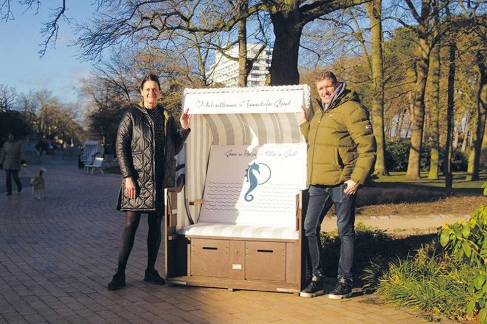 Marketingleiterin Silke Szymoniak und Strandkorbvermieter Markus Bade zeigen einen der neu gestalteten Strandkörbe, die auf der Kurpromenade zum Verweilen einladen.
