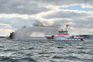 Der Seenotrettungskreuzer FELIX SAND der DGzRS bekämpft den Brand auf einer Segelyacht vor Travemünde.