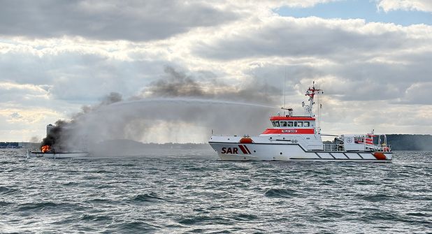 Der Seenotrettungskreuzer FELIX SAND der DGzRS bekämpft den Brand auf einer Segelyacht vor Travemünde.