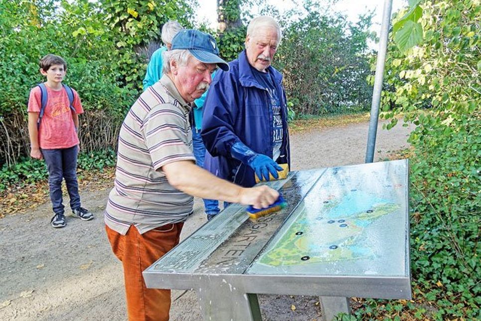 Hans-Peter Kirscht und Dieter Orzelak, zwei der Schlossgartenführer beginnen mit dem Übersichtsschild am Eingang an der Stadtbucht.