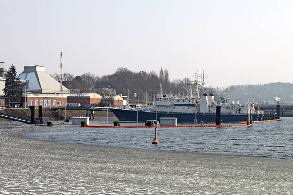 Die Unglücksstelle (Blick von der Straße „Am Holm“) ist mit Ölsperren gesichert.
