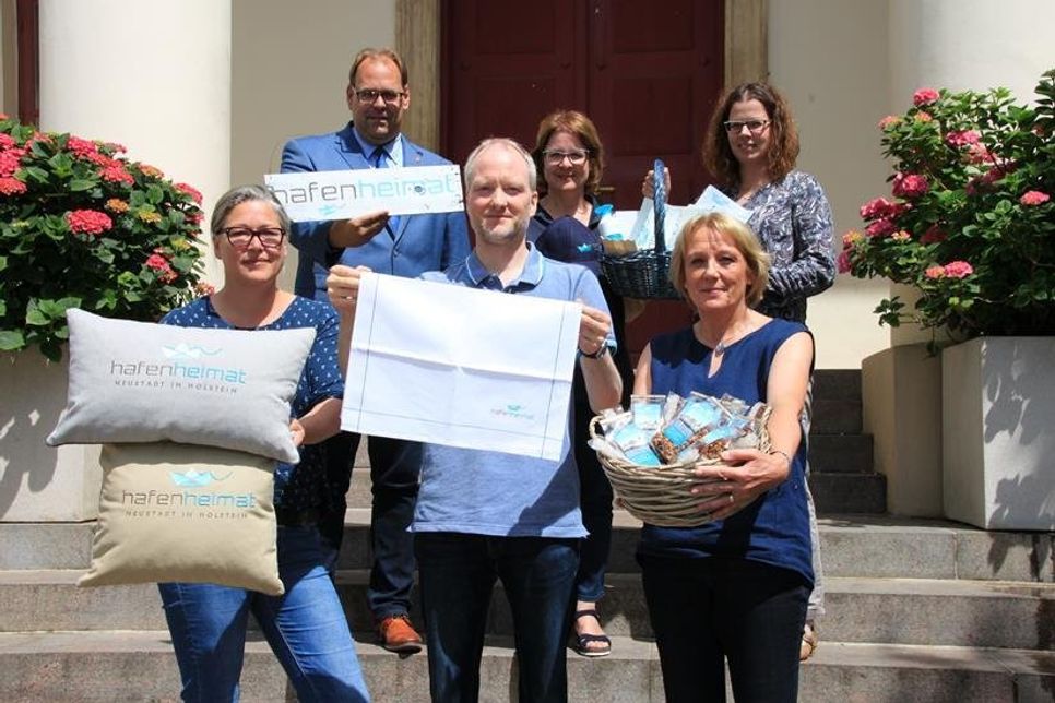 Gemeinsam möchten Katrin Körting (ZwergNase), Bürgermeister Mirko Spieckermann, Heiko Witt (Fachgeschäft Schlüter), Stadtmarketingkoordinatorin Andrea Brunhöber, Susanne Scholz (Tee und Schenken) und Vera Heß (Werkleiterin Tourismus-Service; v. lks.) das heimathafen-Logo über Neustadts Grenzen hinaustragen.