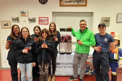 Alexander Wengelewski von den Stadtwerken probiert mit den jungen Feuerwehrmitgliedern die neue Slush-Maschine aus.