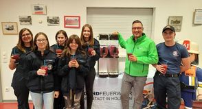 Alexander Wengelewski von den Stadtwerken probiert mit den jungen Feuerwehrmitgliedern die neue Slush-Maschine aus.