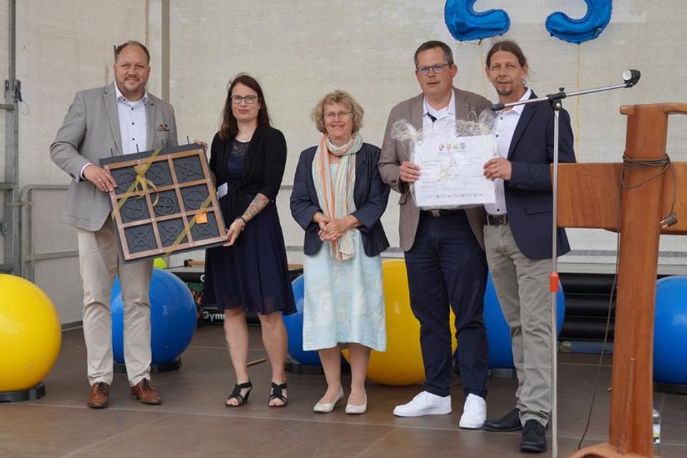 Geschenke zum Jubiläum gab es von Landrat Timo Gaarz (lks.) und Bürgermeister Sebastian Rieke (2. v. re.). 1. Vorsitzende Mechtild Piechulla (Mi.), Einrichtungsleiterin Janine Perk (2. v. lks.) und Fachbereichsleiter Matthias Thoms (re.) nahmen sie dankend entgegen.