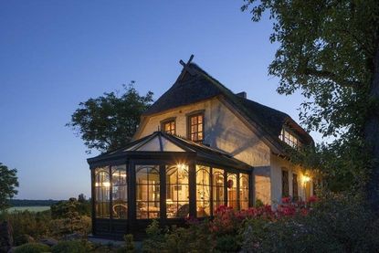 Eine gemütliche Ruheoase in jeder Jahreszeit: Ein Wintergarten schenkt dem Haus einen besonderen Rückzugsort.