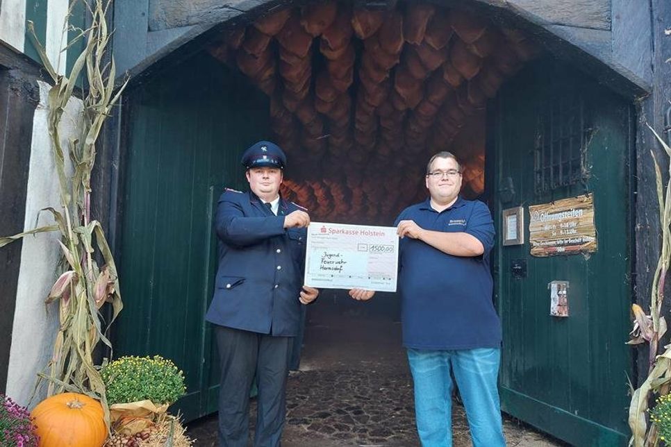 Florian Schulz (Betreuer der Jugendfeuerwehr, lks.) nahm den Scheck von Braasch-Verkaufsleiter Herbert Marek entgegen.