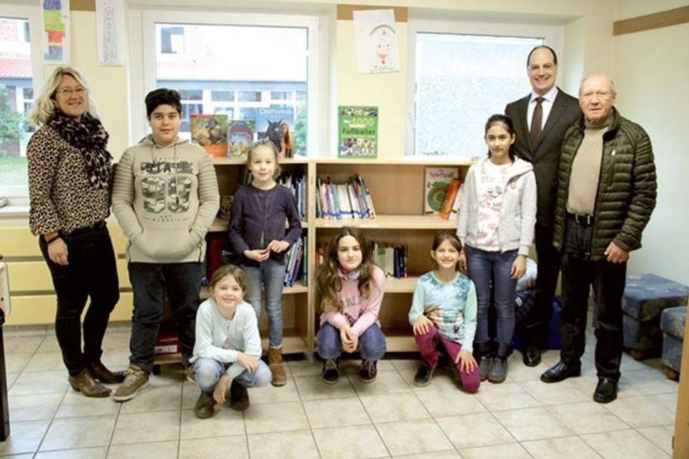 Antje Sagawe, Stefan Frahm und Uve Petersen, mit Grundschülern zur Bücherregalübergabe in der Grundschule Grube.