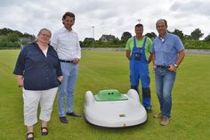 Klimaschutzmanagerin Regine Maaß (von links), Bürgermeister Robert Wagner, Bauhofmitarbeiter Holger Höppner und Bauhofleiter Rüdiger Helm präsentieren der Presse den neuen Mähroboter. (Foto: René Kleinschmidt)