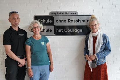 Das neue Schild wurde mit Hilfe von Hausmeister Björn Schildknecht direkt aufgehängt. Schulleiterin Doris Jürs (re.) und Birte Wolter von der Aktionsgruppe der Gemeinde freuten sich über die Auszeichnung.