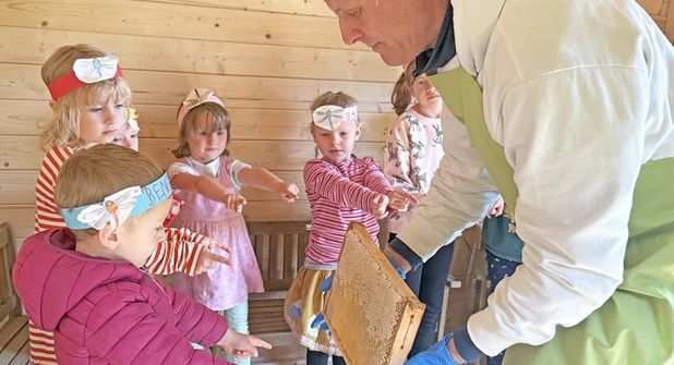 Imker Sven Petersen gab Einblicke in die Natur der Honigbienen und die Honiggewinnung; hier reicht er eine volle schwere Wabe in der Gruppe herum.