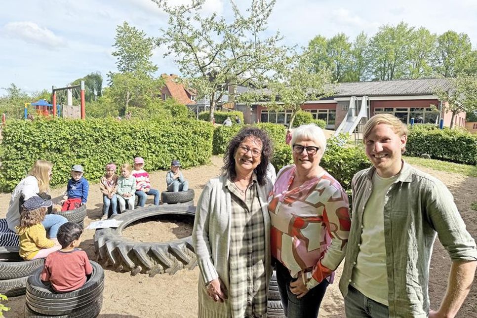 Erzieher Marvin Pfeiffer und Kindergartenleiterin Brigitte „Gitti“ Lehmann freuten sich über die Spende von Dörte Schmidt (m.), Inhaberin von Schmidt‘s Augenblick, zur Finanzierung des Imkerprojekts im Rahmen einer umfassenden Umweltbildung im Ascheberger Kindergarten Am Mühlenholz. Das Singen von Frühlingsliedern (Hintergrund) zählte dazu.