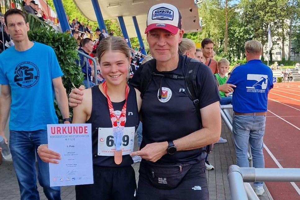 Pia Feline Loors nach der Siegerehrung mit Medaille neben ihrem Heimtrainer Andreas Boller.