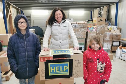 Kinder helfen Kindern: Lennox (11, li.) und Milena (6) haben einen Umzugskarton mit warmer Kleidung, aus denen sie bereits rausgewachsen sind, an Bürgermeisterin Bettina Schäfer übergeben.