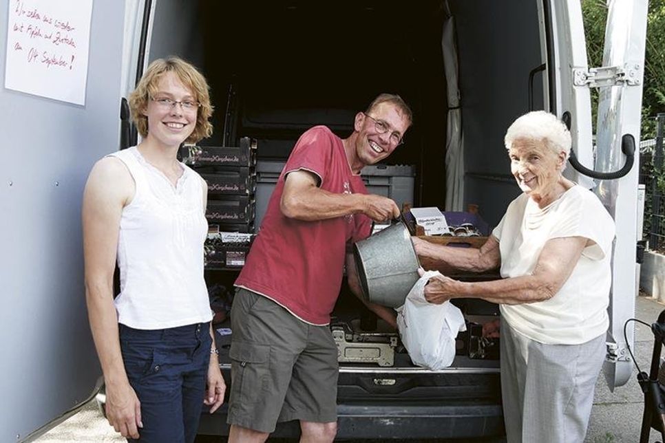 Klaus Minners und Tochter Maria bei der Arbeit. Kundin Annemarie Schutte freut sich über das frisch geerntete Obst direkt vom Erzeuger. (Foto: VA/hfr)