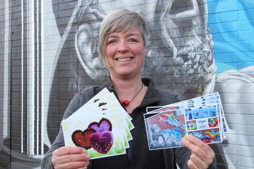Heike Rhein mit den druckfrischen Postkarten zu den Projekten „775 Herzen“ und „Neustadt ist bunt“.