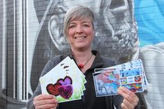 Heike Rhein mit den druckfrischen Postkarten zu den Projekten „775 Herzen“ und „Neustadt ist bunt“.