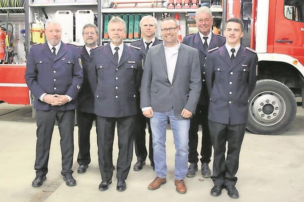 Wehrführer Manfred Lübke (2. v. lks.) mit Bürgermeister Harald Behrens sowie den Geehrten und Beförderten.
