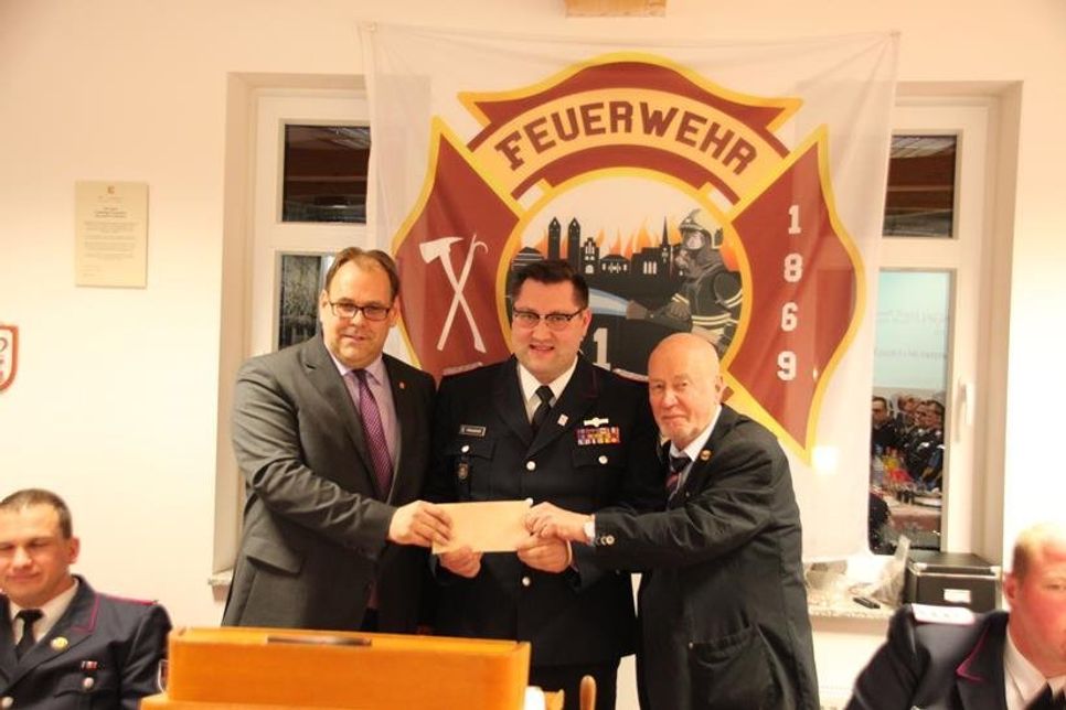 Ein „Flachgeschenk“ gab es von Bürgermeister Mirko Spieckermann (lks.) und Bürgervorsteher Sönke Sela (re.) für die Freiwillige Feuerwehr Neustadt, das Wehrführer Alexander Wengelewski entgegennahm.