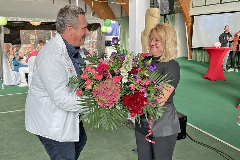 Als Zeichen der Anerkennung für ihr Engagement im Vereinsheim überreicht Jens Krause (zweiter Vorsitzender) einen bunten Blumenstrauß an Olga Neu.