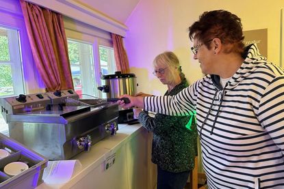 Edith Bouman und Traute Hoffmann nehmen die neue Fritteuse und einen großen Punschtopf in Augenschein. Auch Waffeleisen und eine Kaffeemaschine für über 100 Personen  schaffen neue Möglichkeiten auf dem alten Pfarrhof.