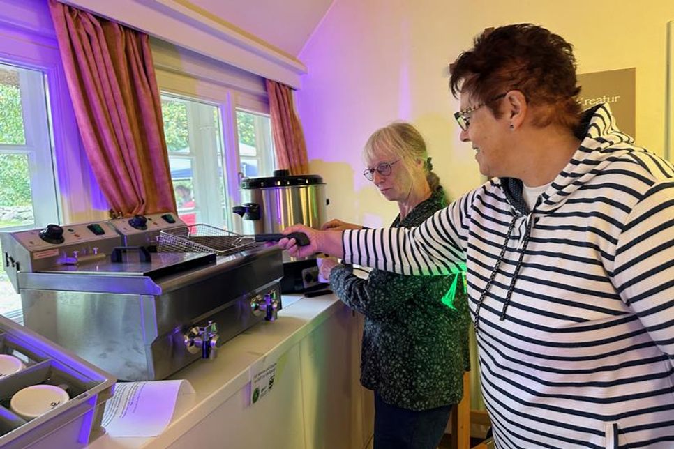 Edith Bouman und Traute Hoffmann nehmen die neue Fritteuse und einen großen Punschtopf in Augenschein. Auch Waffeleisen und eine Kaffeemaschine für über 100 Personen  schaffen neue Möglichkeiten auf dem alten Pfarrhof.