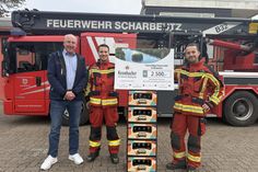 Holger Schattschneider, Gebietsverkaufsleiter Krombacher Brauerei, zusammen mit René Konietzny und Denny Pöhl von der Freiwilligen Feuerwehr Scharbeutz bei der symbolischen Spendenscheckübergabe.