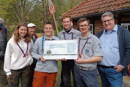 Die Pfadfinder Jalina, Bjarne, Kristaps, Raik mit Lions Club Präsident Dirk Süssenbach (v. lks.).