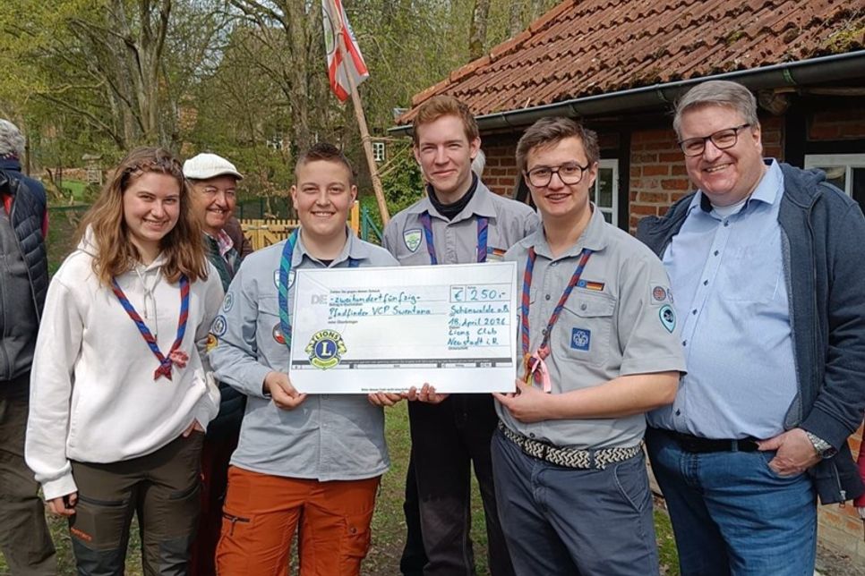 Die Pfadfinder Jalina, Bjarne, Kristaps, Raik mit Lions Club Präsident Dirk Süssenbach (v. lks.).