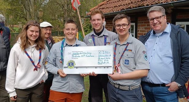 Die Pfadfinder Jalina, Bjarne, Kristaps, Raik mit Lions Club Präsident Dirk Süssenbach (v. lks.).